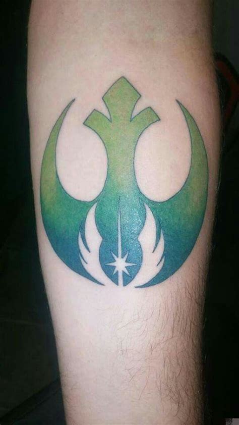 a tattoo on the leg of a man with a green and white star wars symbol