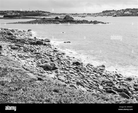 Black And White Landscape Of Rocky Coastline With Hugh Town St Marys