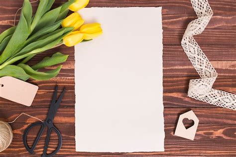 Vista de alto ângulo de papel em branco flores amarelas tesoura