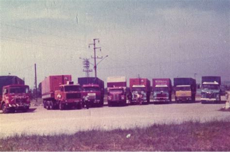 A Group Of Trucks Parked Next To Each Other On The Side Of A Dirt Road