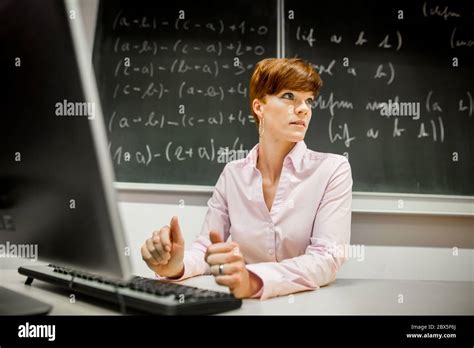 Pretty Young College Teacher Using Computer At Modern Classroom Black