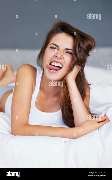 Nothing Like A Little Morning Silliness A Young Woman Pulling Faces While Lying In Bed Stock