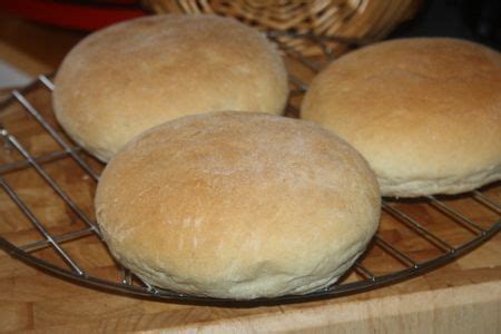 Three Loaves Of Bread Sitting On A Cooling Rack