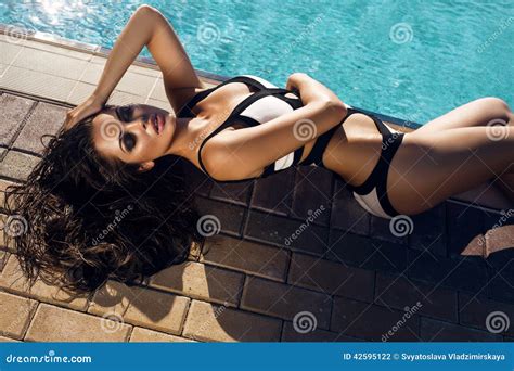 Woman With Long Hair In Bikini Relaxing Beside A Swimming Pool Stock