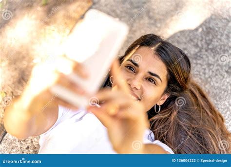 Una Mujer Joven Que Toma Un Selfie Y Una Sonrisa Foto De Archivo