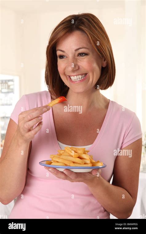 WOMAN EATING FRENCH FRIES Stock Photo Alamy