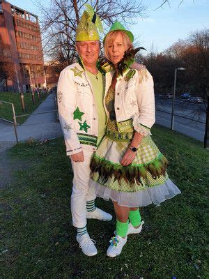 Two People Dressed In Costume Standing Next To Each Other On The Grass