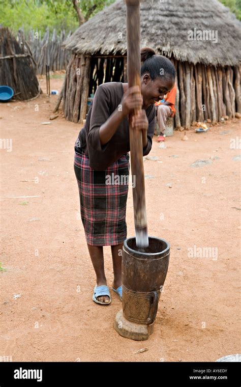 Namibian Girl Pounding Cassava In A Wooden Bowl With Pestle Stick Stock