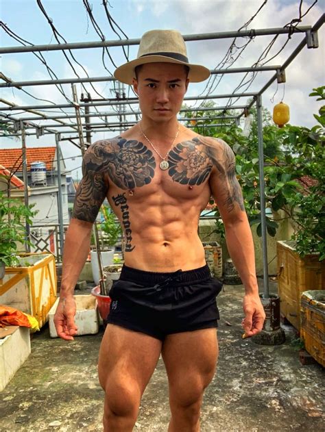 A Man With Tattoos And No Shirt Standing In The Dirt