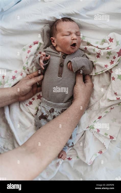 Newborn baby boy held by dad on hospital bed Stock Photo - Alamy