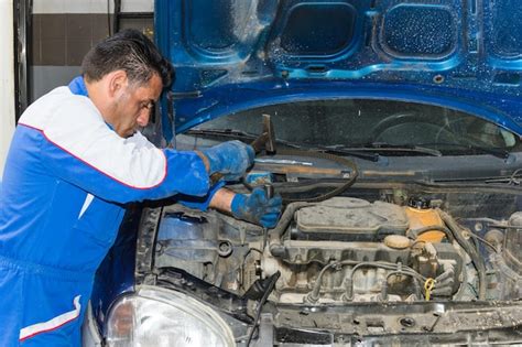 Premium Photo Mechanic Repairing Car Engine In Garage