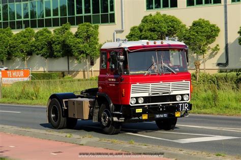 A Red And White Truck Driving Down The Road