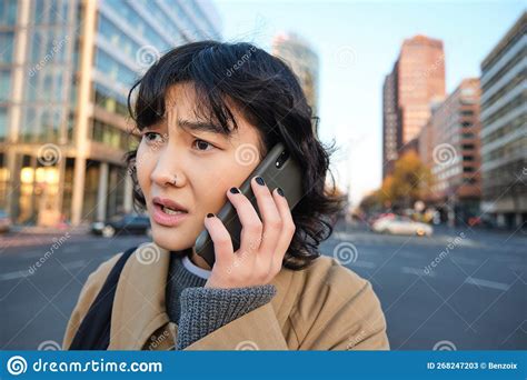 Close Up Portrait Of Concerned Asian Woman Talks On Mobile Phone And