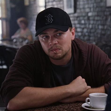 A Man Sitting At A Table With A Coffee Cup In Front Of Him And Looking