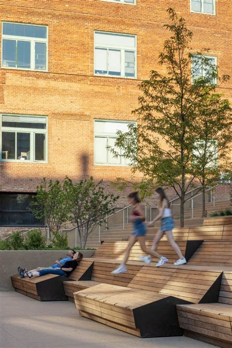 two people are walking up and down the stairs in front of a brick building, while another person ...