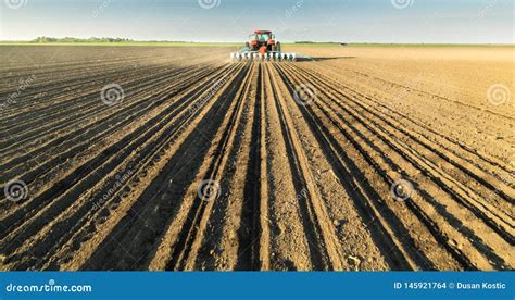 Farmer With Tractor Seeding Soy Crops At Agricultural Field Stock Photo