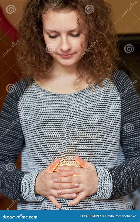 Smiling Happy Woman Holding Crossed Arms On Belly Through Which The