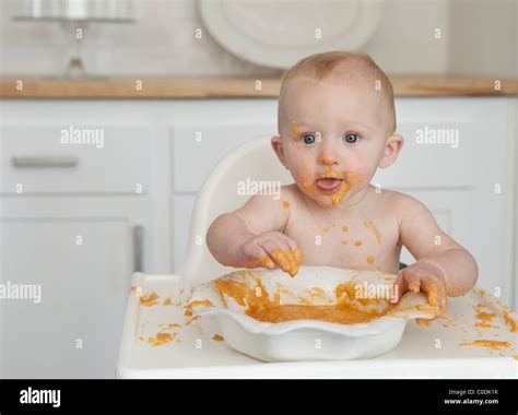 Messy Baby Eating In High Chair Stock Photo Alamy