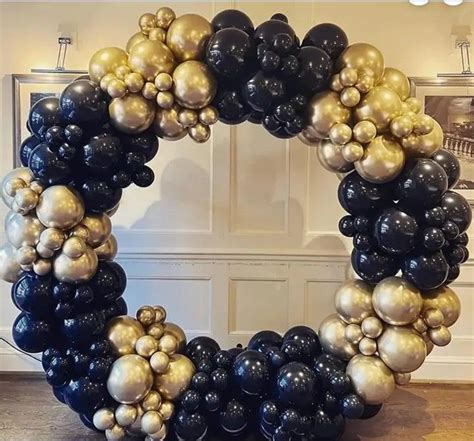 A Wreath Made Out Of Black Gold And White Balloons In The Shape Of A