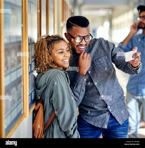 Snapping selfies on campus. an affectionate young couple taking selfies ...