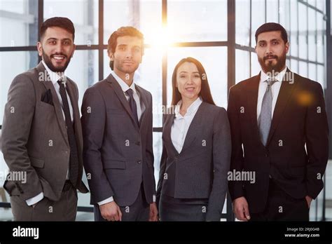 Businessmen With Brunette In Group Posing In Office Lobby Stock Photo Alamy