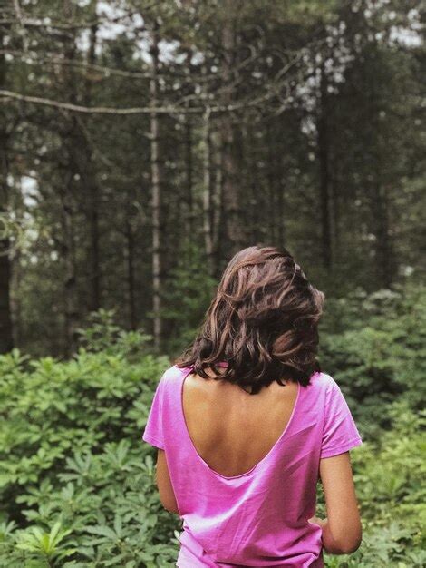 Premium Photo Rear View Of Woman Standing Amidst Trees In Forest