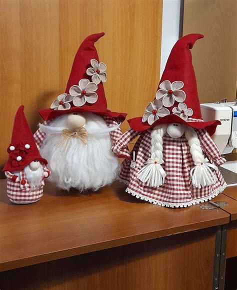 Two Red And White Gnomes Sitting Next To Each Other On A Table With