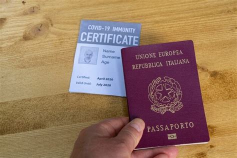 Premium Photo Cropped Hand Holding Passport On Wooden Table