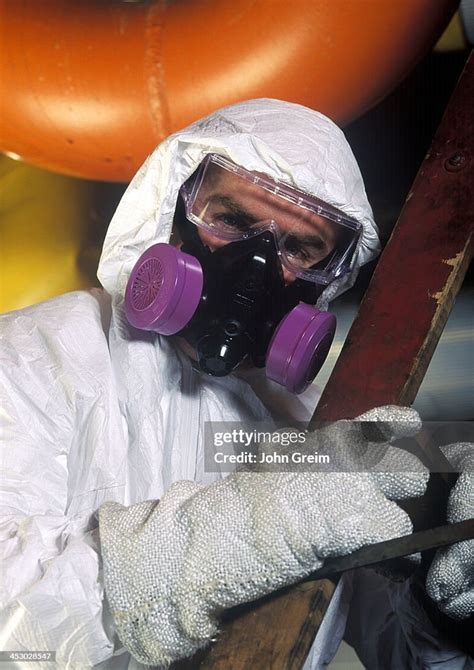 Asbestos Removal Worker With Protective Suit And Mask At A Industrial