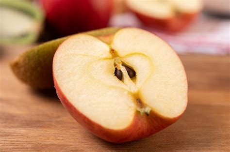 Manzana Cortada Por La Mitad En Una Mesa De Madera Foto Gratis