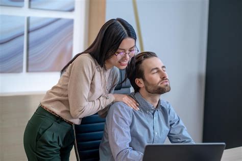 Premium Photo Smiling Young Female Personal Assistant Massaging The Shoulders Of Her Male Boss