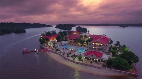 an aerial view of a resort on the water at sunset or dawn with clouds in the sky