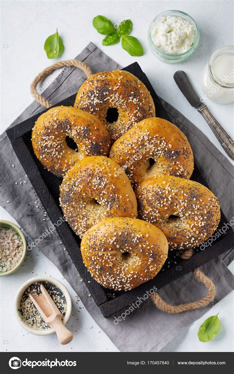 Variety fresh whole-grain bagels with poppy seeds, sesame seeds and ingredients for breakfast on ...