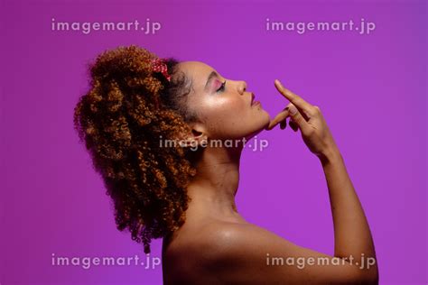 Biracial Woman With Pink Eye Shadow And Lipstick Touching Chin Purple