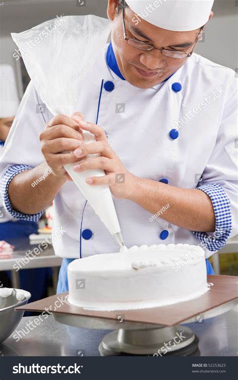 Chef Or Baker Decorating Cake With White Whipped Cream Stock Photo