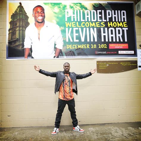 a man standing in front of a sign with his hands up and arms wide open