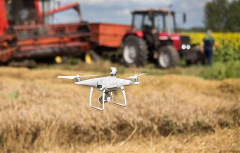 Drone in Front of Tractor and Combine Harvester in Field Stock Photo ...