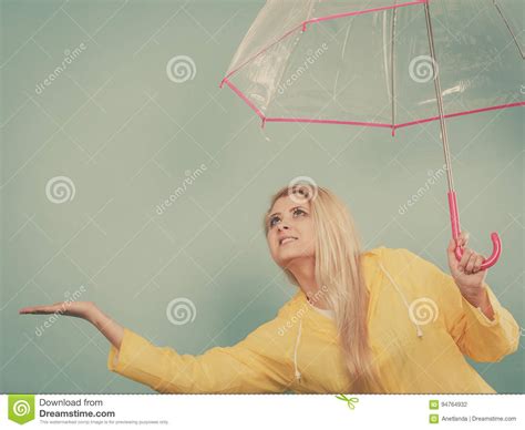 Woman Wearing Raincoat Holding Umbrella Checking Weather Stock Photo