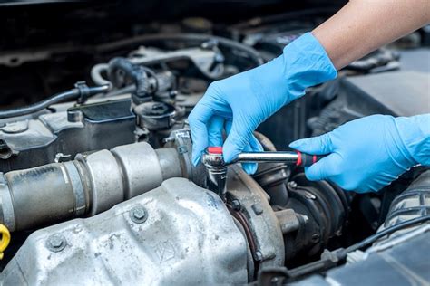 Primer plano de las manos de un mecánico de automóviles que comprueba