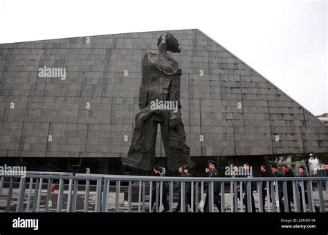 Officers Walk Past A Statue At The Memorial Hall Of The Victims In