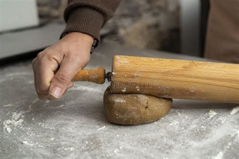 Two Hands Rolling The Biscuit Dough Evenly Over Flour With A Rolling