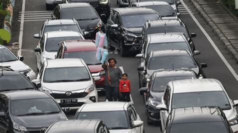 Pedagang Asongan Berjalan Di Antara Kepadatan Kendaraan Bermotor Di