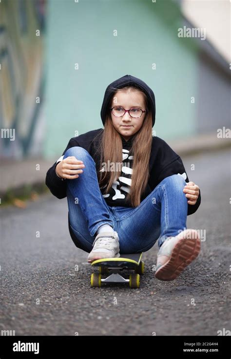 Girl Sitting On Skateboard Stock Photo Alamy