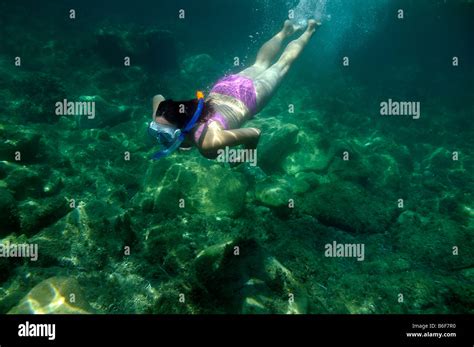 Woman With A Snorkel And Diving Goggles Scuba Diving In The Sea