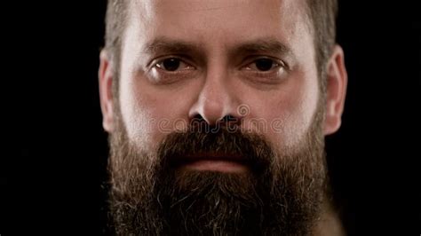 Big Close Up Of The Harsh Face Of A Bearded Adult Man With Brown Eyes