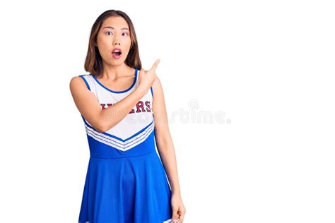 Young Beautiful Chinese Girl Wearing Cheerleader Uniform Surprised