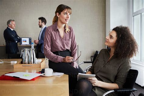 Colleagues In Office Chatting Stock Photo