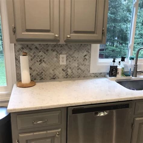 A Kitchen With Gray Cabinets And White Counter Tops Stainless Steel