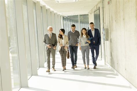 Group Of Corporate Business Professionals Walking Through Office