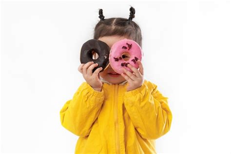 Niña linda con donas sobre un fondo blanco Foto Premium